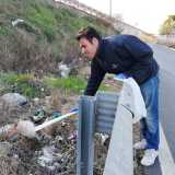 Estrae anche un bastone, con il quale si aiuta a raccogliere gli oggetti pi� lontani gettati oltre il guardrail